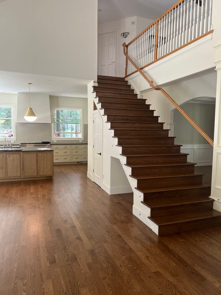 Custom dark oak stair treads with white risers and natural handrail, Rathdrum Idaho