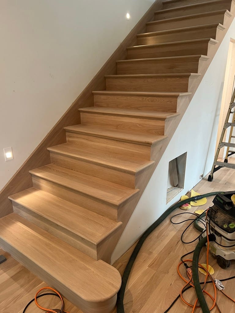 Unfinished light oak open-tread staircase mid-construction, North Idaho