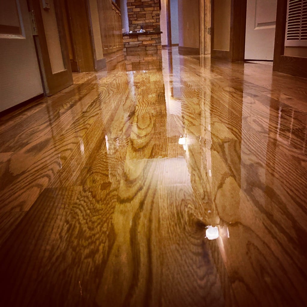 High-gloss wet finish on freshly refinished hardwood floor, North Idaho