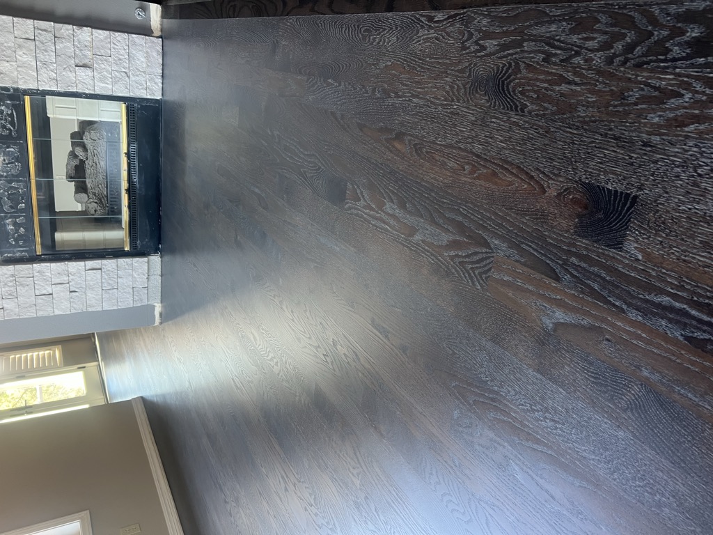 Cerused dark-stained hardwood floor with white grain highlights